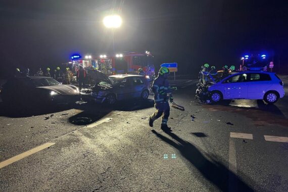 Verkehrsunfall mit drei Fahrzeugen, Feuerwehr im Einsatz, Verletzte werden versorgt.