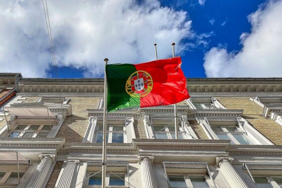 Portugal Flagge mit Siegessymbolik, António José Seguro als neuer Präsident im Hintergrund.