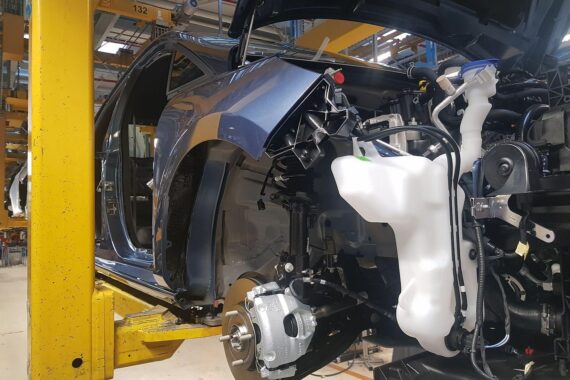 Bild zeigt Elektroautos in einer Fabrik, symbolisiert Unsicherheit im E-Automarkt durch EU-Politik.