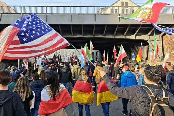 Demonstranten in Berlin mit Flags, skandieren für Regimewechsel im Iran und feiern Luftangriffe.