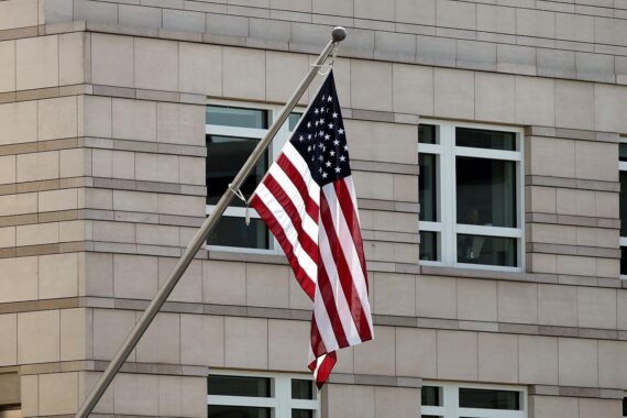 US-Flagge vor dem Hintergrund von Protesten gegen Einwanderungsmaßnahmen in Minnesota.