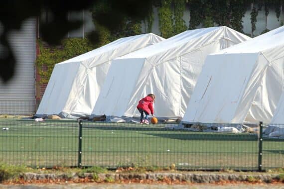 Flüchtlingskind in Zeltstadt, Symbol für die humanitäre Krise und unklare Rückkehrperspektiven.