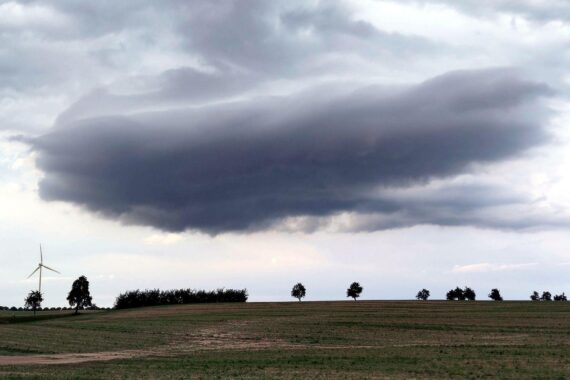 Dunkle Wolken über einem Acker, mögliches Unwetter mit Gewittern und starkem Wind.