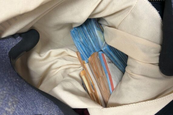 Beschlagnahmtes Bargeld in einem Rucksack, Zollbeamte bei Kontrolle im Zug.