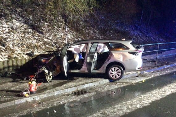 Verkehrsunfall mit stark beschädigtem Fahrzeug, Feuerwehr und Rettungskräfte vor Ort, Verletzte.