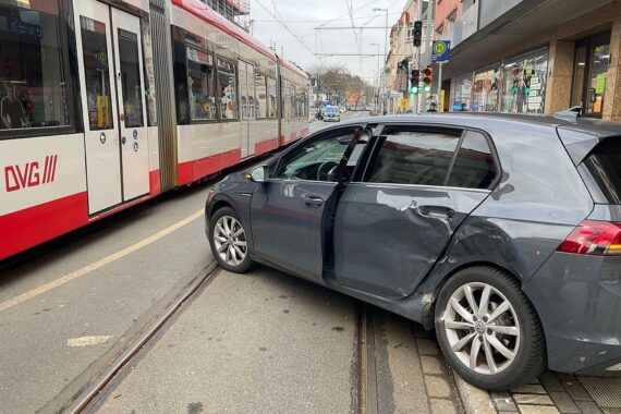 Zusammenstoß zwischen Straßenbahn und Pkw, Feuerwehr sichert Unfallstelle, Rettungsdienste vor Ort aktiv.
