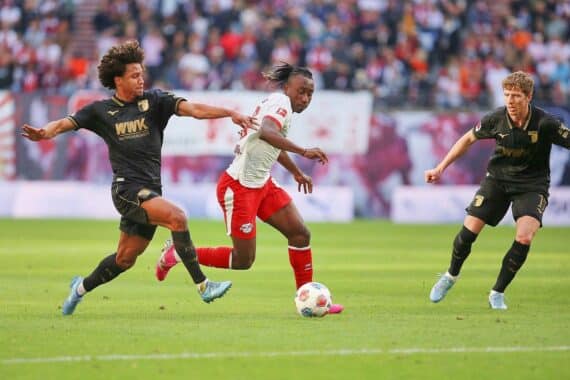 Leipzig-Spieler jubeln nach dem entscheidenden Eigentor gegen Augsburg in packendem Bundesliga-Spiel.