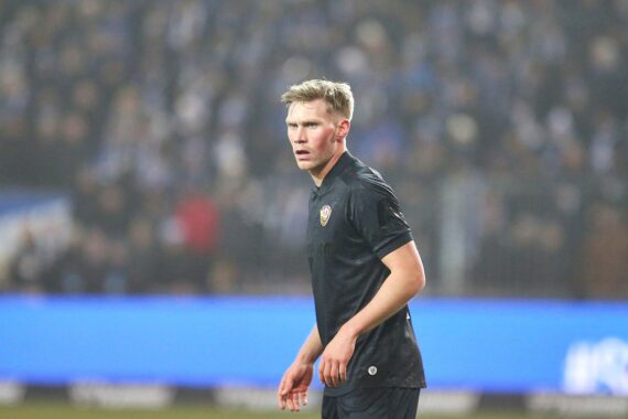 KSC-Spielszene mit Spielern, die um einen Ball kämpfen, im Hintergrund Stadionatmosphäre.