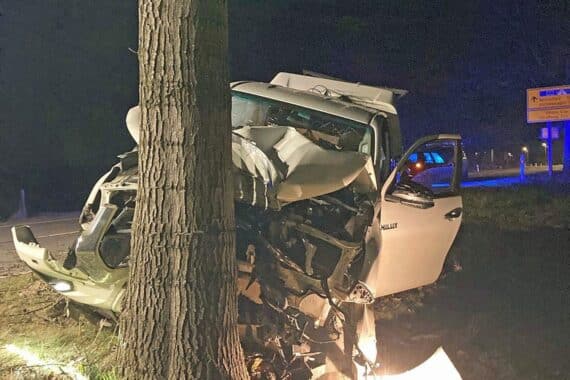 Unfallstelle mit Polizei, beschädigtem Auto und Baum, Alkoholisierung des Fahrers im Fokus.