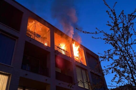 Brennende Wohnung in Senioreneinrichtung, Feuerwehr im Einsatz, Bewohner evakuiert, Rauchentwicklung sichtbar.