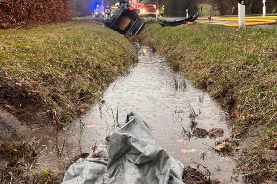 Feuerwehrleute löschen brennendes Auto nach schwerem Unfall in Horn-Bad Meinberg, Rettungskräfte vor Ort.