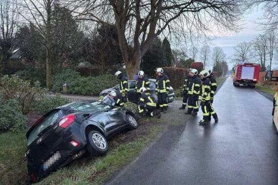 Unfallauto im Graben, Feuerwehr und Rettungsdienst sichern die Unfallstelle, sanitäre Versorgung.