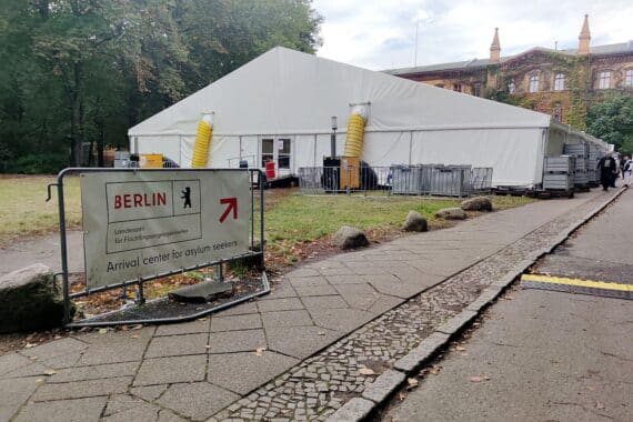 Asylbewerber im Ankunftszentrum, Wartende vor einem Gebäude, Hoffnung auf Schutz in Deutschland.