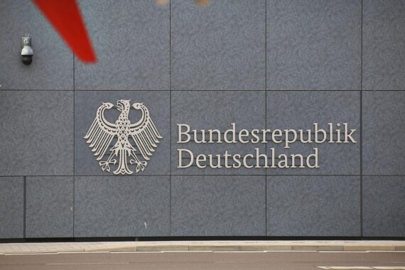 Schriftzug "Bundesrepublik Deutschland" vor einem Krankenhaus, symbolisiert Kooperation in Krisensituationen.