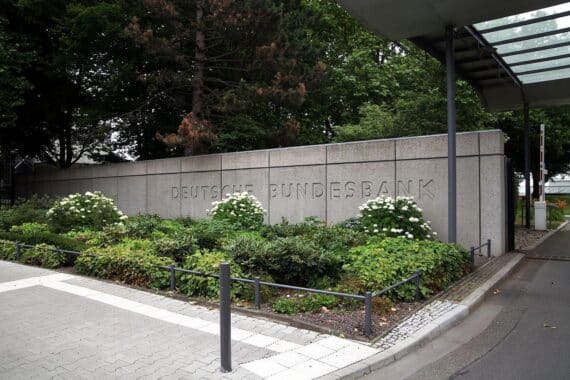 Bundesbank-Gebäude in Frankfurt mit Grafiken zu Verlusten und erfolgreichen Finanzmaßnahmen.