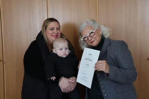 Olga und Levi Dingis erhalten Urkunde von Sorya Lippert zur Ehrenpatenschaft des Bundespräsidenten.