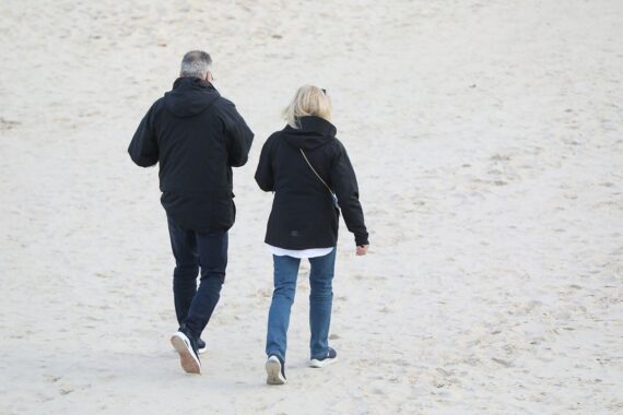 Ein Paar spaziert am Strand, symbolisiert Zusammenhalt und Verteidigung traditioneller Werte.