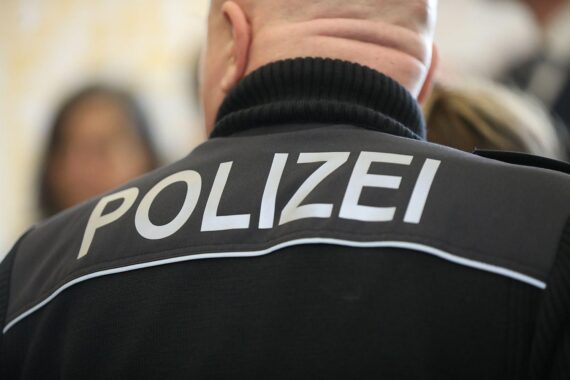 Tatortabsperrung durch Polizei, Einsatzkräfte vor einem Einfamilienhaus, Traurige Stille nach Tragödie.
