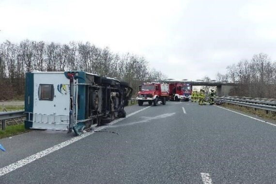Ein überschlagenes Wohnmobil an der Autobahn, umgeben von Polizei- und Rettungskräften.
