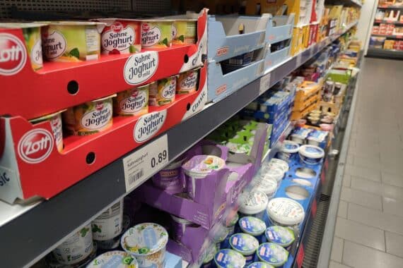 Joghurt in einem Supermarktregal, symbolisiert Lebensmittelversorgung und Stabilität vor Ostern.