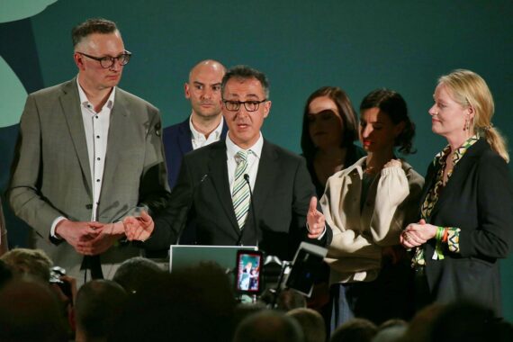 Cem Özdemir mit grüner Hintergrundkulisse, symbolisch für politischen Wandel und soziale Gerechtigkeit in Baden-Württemberg.