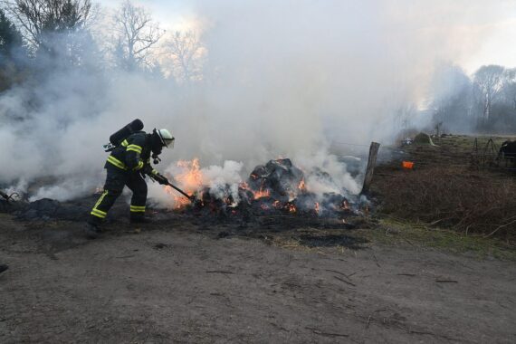 Heuballen auf Weide brennen, Feuerwehr im Einsatz, Brandstiftung vermutet, Polizei sucht Hinweise.