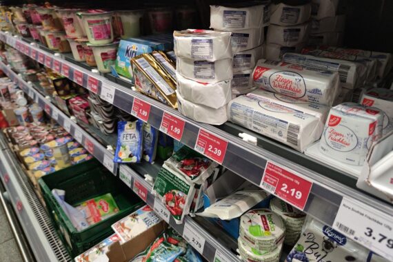 Käseauslage im Supermarkt, symbolisiert Preisentwicklung und Inflation im Lebensmittelbereich.
