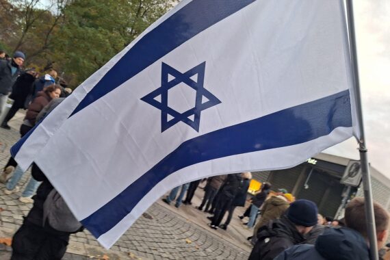 Pro-Israel-Demonstration mit Menschen, Flaggen und Plakaten zur Unterstützung Israels und gegen Hisbollah.