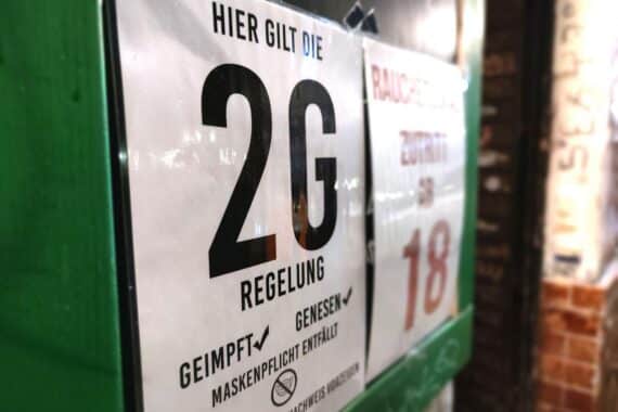 2G-Hinweisschild an einer Bar steht für vergangene Corona-Maßnahmen und juristische Herausforderungen.
