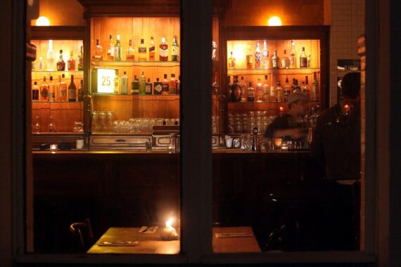 Ein belebtes Restaurant mit Gästen, Preisen auf der Speisekarte, gemütlicher Atmosphäre zur Gastronomie.