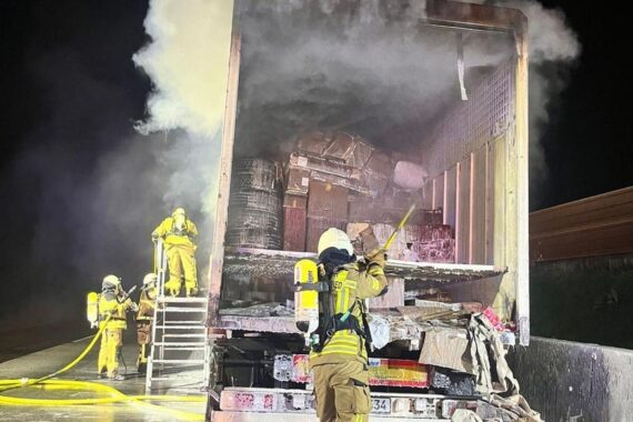 Brennender Lastwagen auf Autobahn, Feuerwehr im Einsatz, Anhänger wird ausgeräumt.