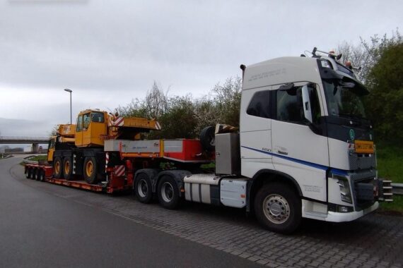 Massiv überladener Sattelzug mit Autokran auf Autobahn, Polizei kontrolliert und stoppt Fahrzeug.