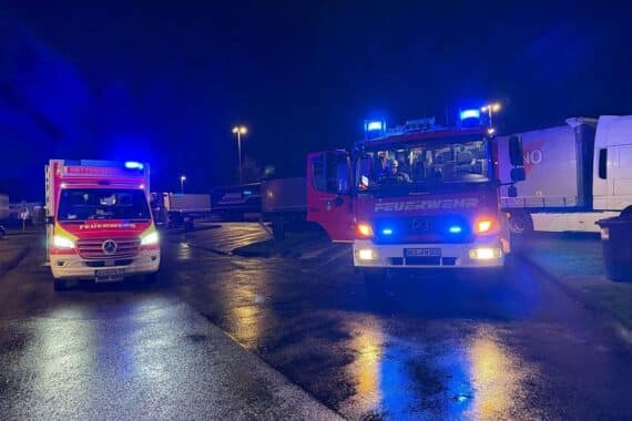 Rettungsdienst und Feuerwehr bei medizinischem Notfall auf Rastplatz, Sicherheitsmaßnahmen werden getroffen.