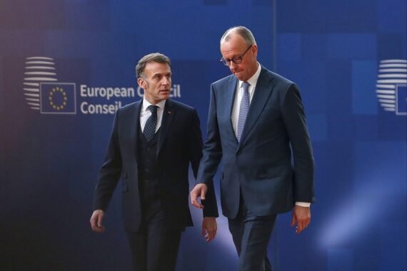 Emmanuel Macron und Friedrich Merz beim EU-Gipfel, symbolisieren europäische Geschlossenheit und wirtschaftliche Zusammenarbeit.