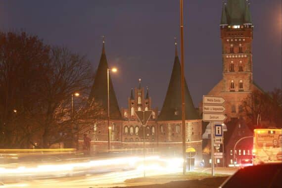 Holstentor in Lübeck mit Mietspiegel-2025-Info und steigenden Nettokaltmieten im Hintergrund.