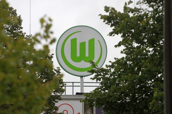VfL Wolfsburg und Werder Bremen während eines angespannten Bundesligaspiels, Polizeipräsenz sichtbar.