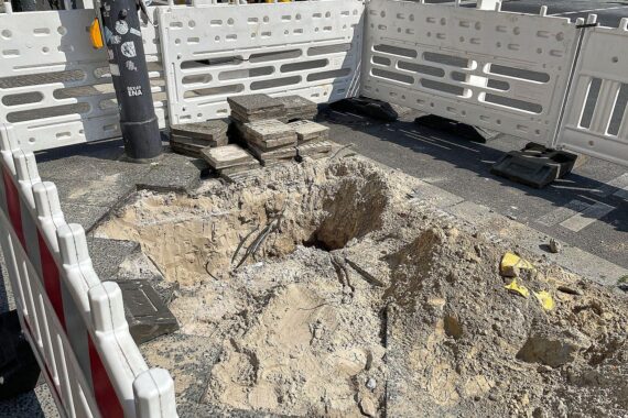 Baustelle in Wiesbaden mit abgesperrter Straße und Hinweisschildern zur Sanierung sichtbar.