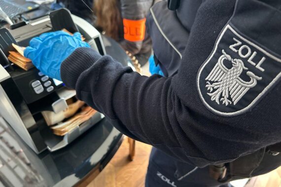 Razzia gegen Schwarzarbeit: Einsatzkräfte durchsuchen Büros, Geld und Beweismittel sichergestellt.