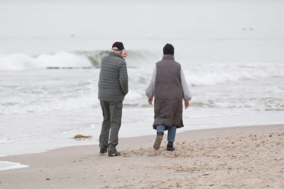 Eine Gruppe von Menschen am Strand, entspannt, symbolisiert die Idee von Gleichheit und Gemeinschaft.