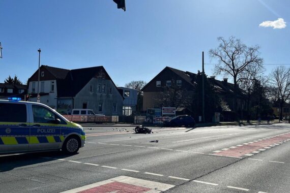 Unfallstelle mit Motorrad und Pkw, Polizei vor Ort, schwer verletzter Motorradfahrer.