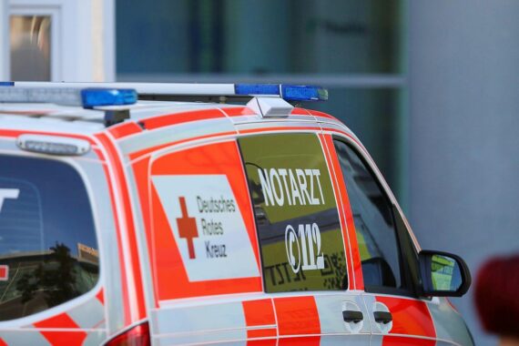 Unfall an Kreuzung: Rettungswagen, verletzter Fahrer, beschädigte Autos, Polizei vor Ort.