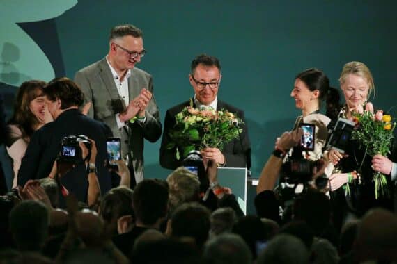 Cem Özdemir, umgeben von grünen Symbolen, feiert seinen Wahlerfolg in Baden-Württemberg.