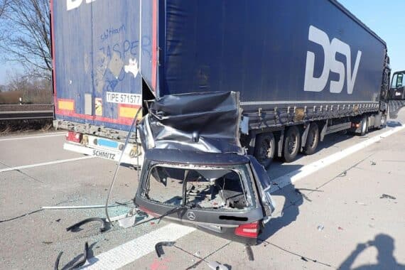 Schwerer Unfall: Abgerissene Fahrzeugteile einer E-Klasse nach Kollision mit Sattelzug.