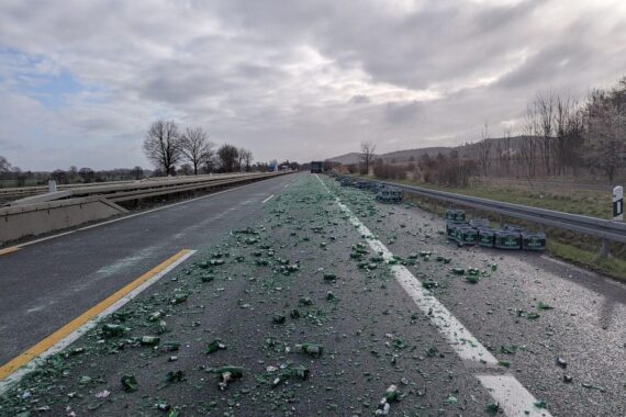 Unfallstelle auf Autobahn mit verstreuten Getränkekisten nach unzureichender Ladungssicherung eines Sattelzugs.