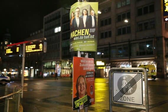 Wahlplakate zur Landtagswahl in Baden-Württemberg, umgeben von Symbolen russischer Einflussnahme und Manipulation.