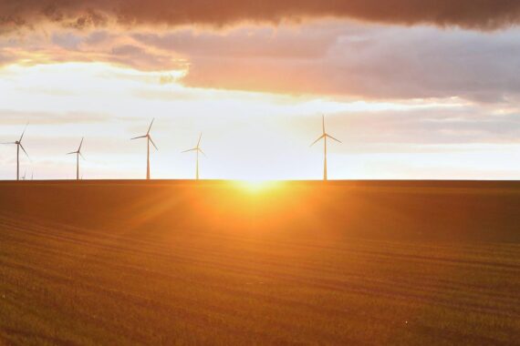 Windräder vor bewölktem Himmel, symbolisieren wechselhaftes Wetter in Nordrhein-Westfalen.