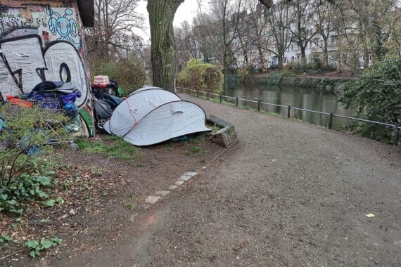Obdachlose Jugendliche in urbaner Umgebung, die ihre Notsituation in einem Zeltlager erleben.