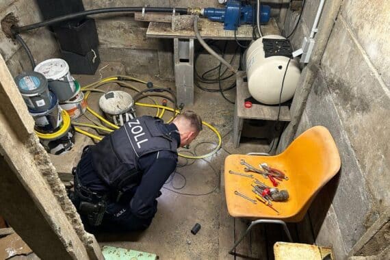 Zollbeamte durchsuchen Gartenhütte, Beweismittel sichern, Schwarzarbeit aufdecken, Schreckschusswaffe gefunden.