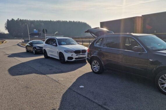 Zollbeamte kontrollieren BMW-Fahrzeuge an der Grenze; Verdacht auf Steuerhinterziehung durch falsche Belege.