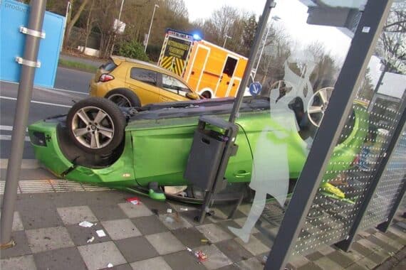 Seat Ibiza auf dem Dach in Bushaltestelle nach Unfall, Fahrzeuge stark beschädigt, Verletzte.